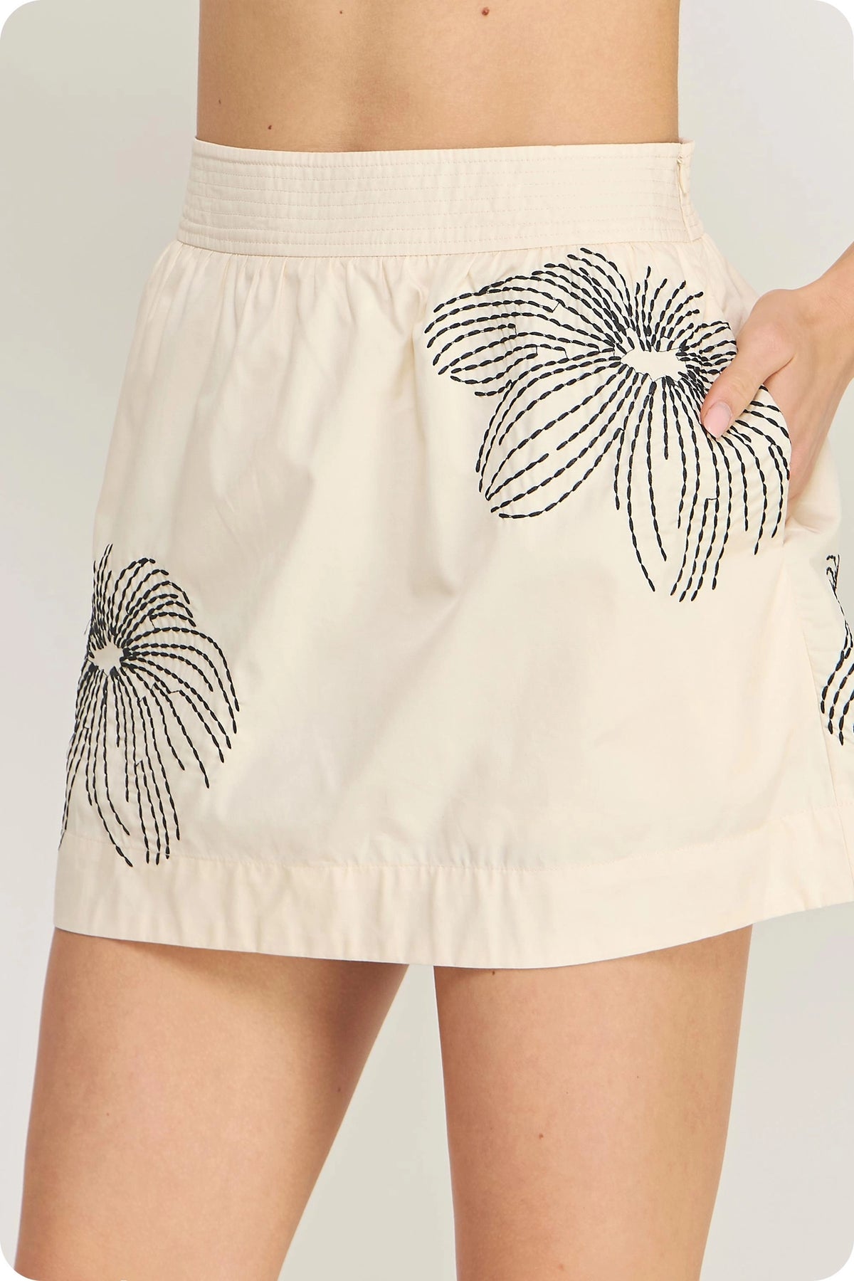 Strut & Bolt ecru mini skort with black floral embroidery and a wide waistband.